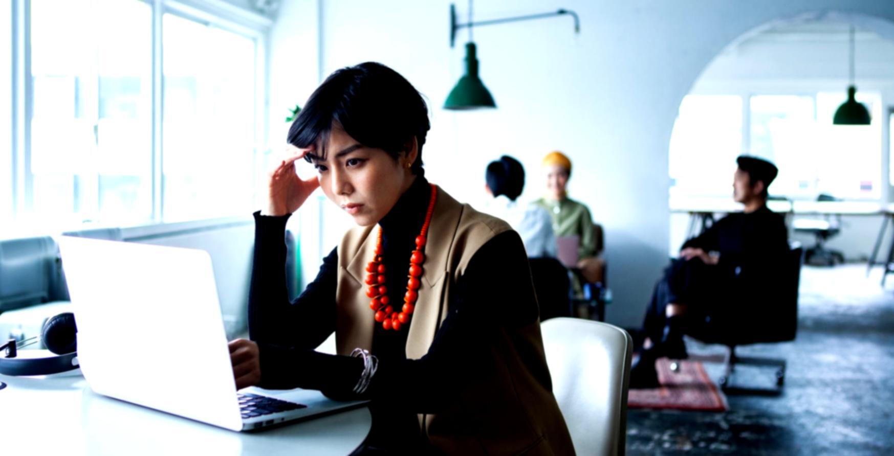 Teilnehmer analysiert Finanzdaten am Laptop mit strukturierten Arbeitsunterlagen